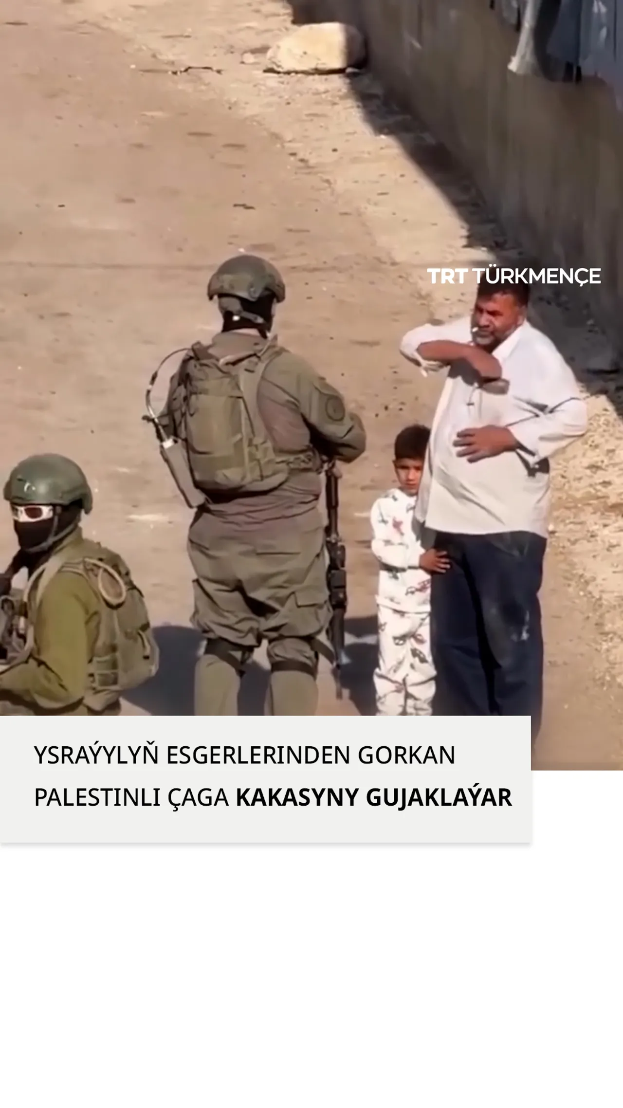 Palestinli çaga Ysraýylyň esgerleri köçede kakasy bilen özüni saklanda, gorkup, kakasyny gujaklaýar