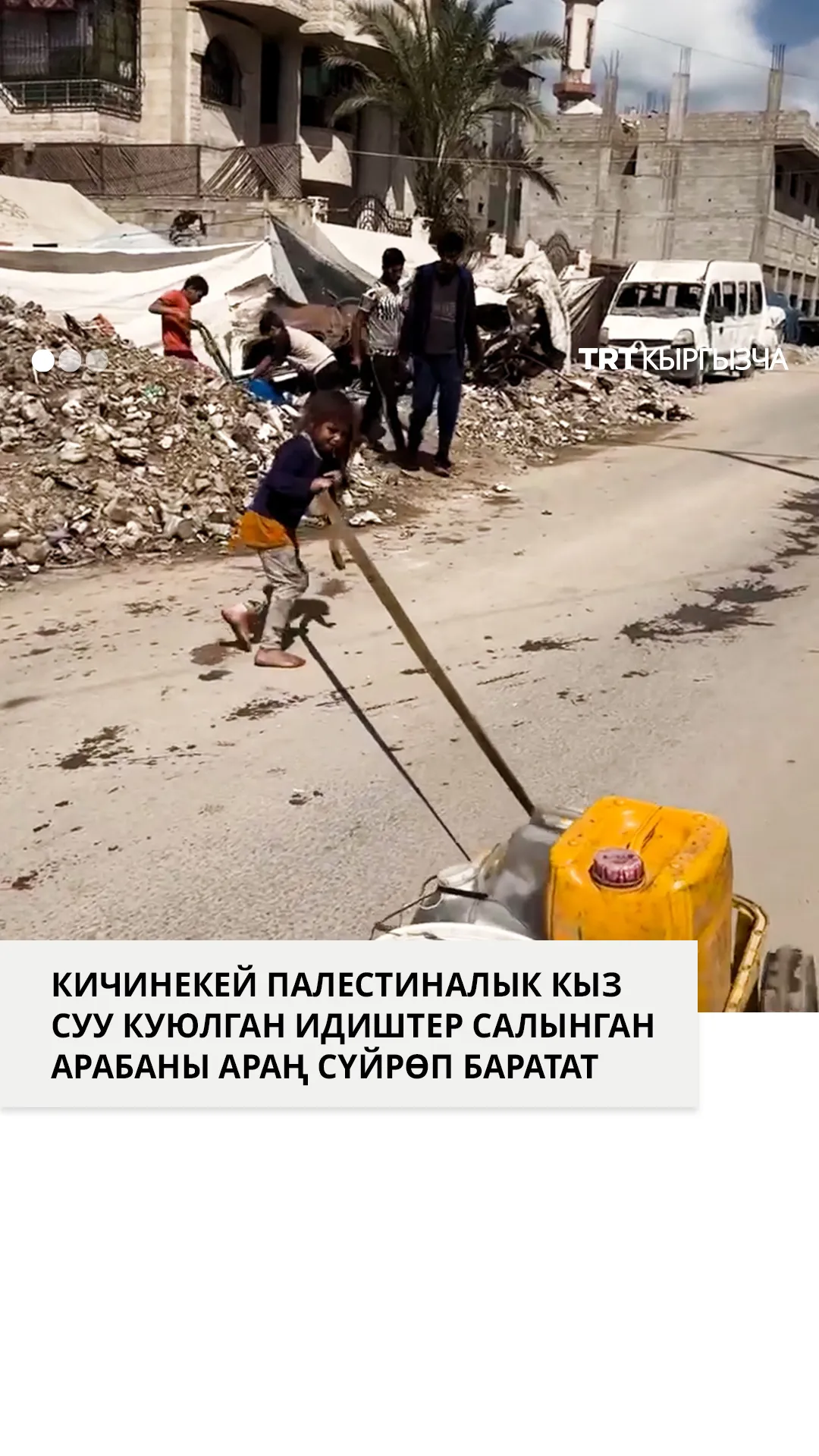 Кичинекей палестиналык кыз суу куюлган идиштер салынган арабаны араң сүйрөп баратат