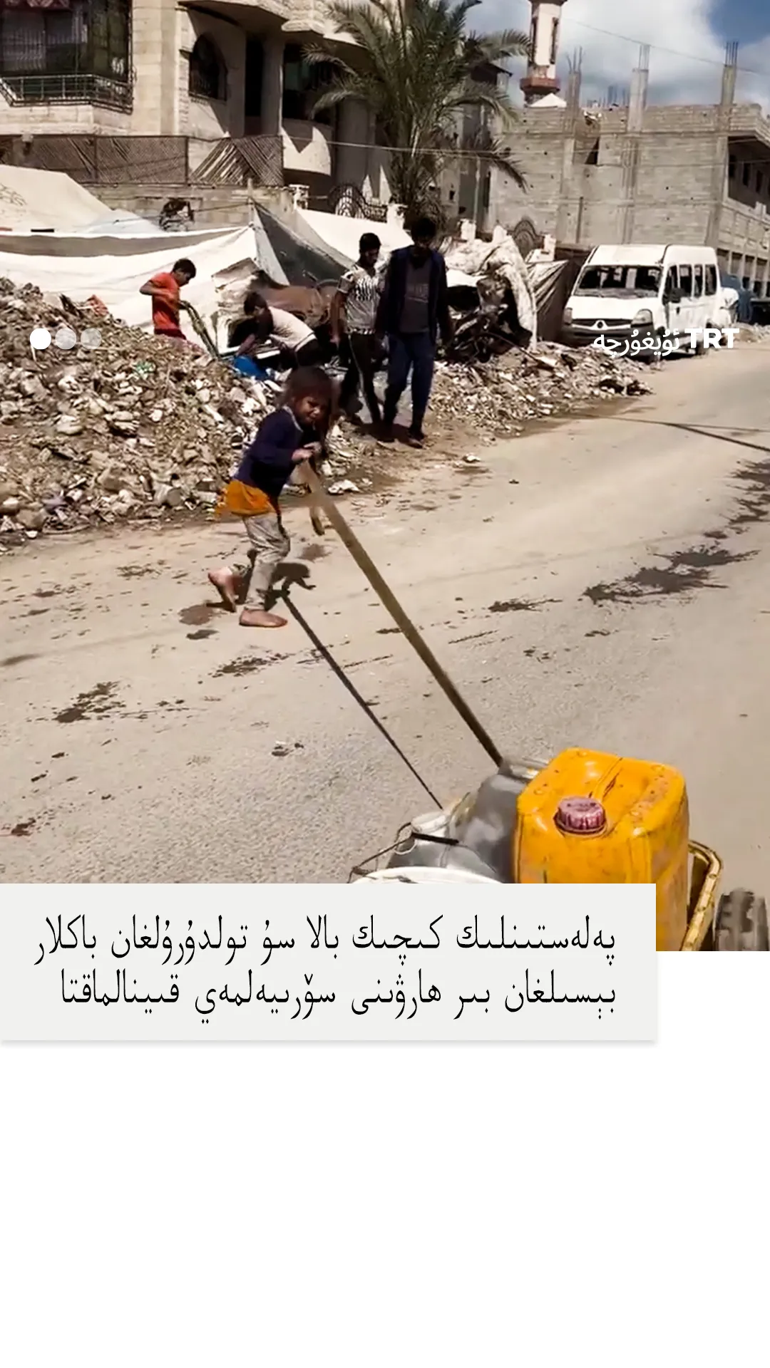 پەلەستىنلىك كىچىك بالا سۇ تولدۇرۇلغان باكلار بېسىلغان بىر ھارۋىنى سۆرىيەلمەي قىينالماقتا