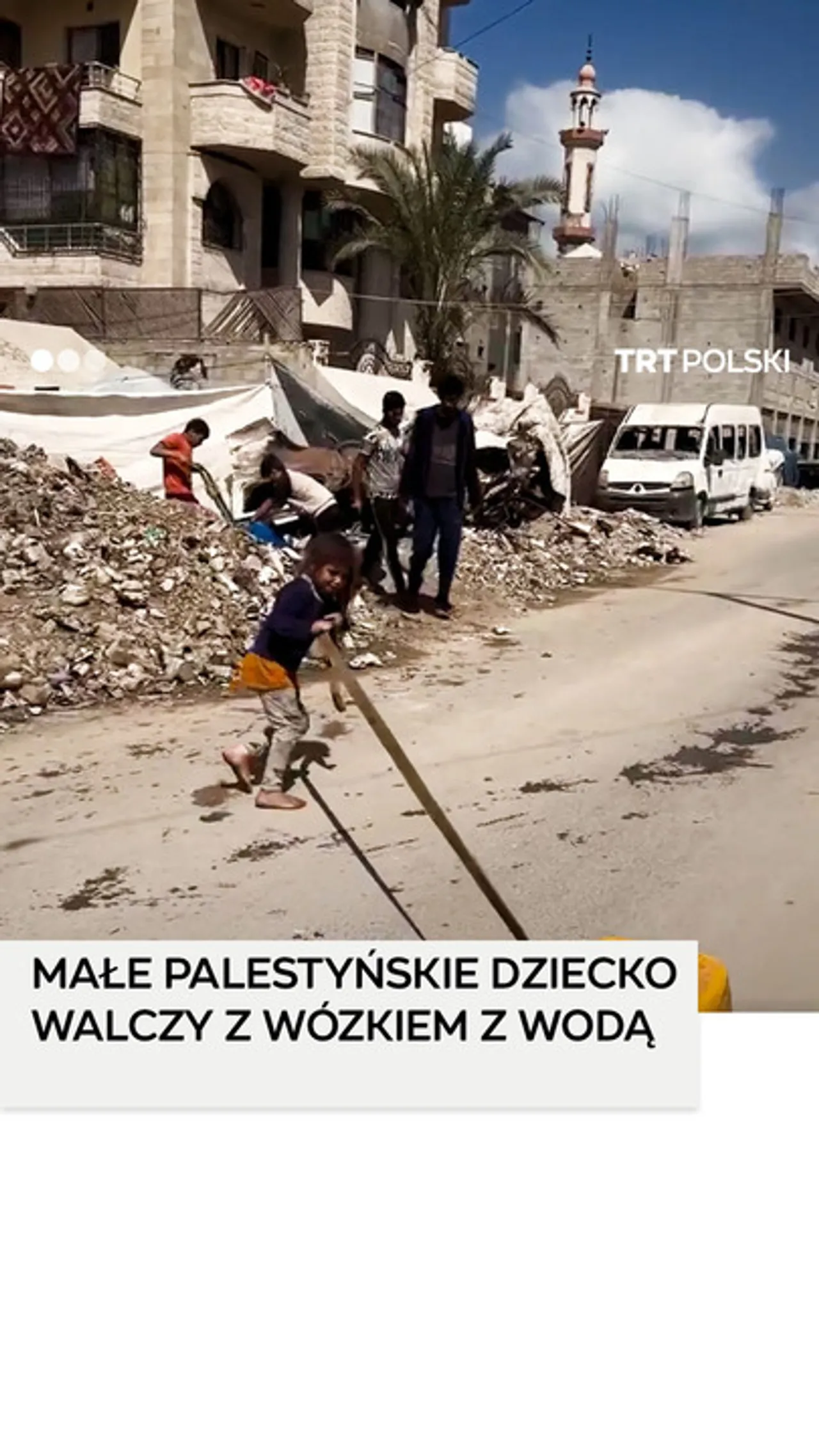 Małe palestyńskie dziecko z trudem ciągnie wózek z wodą