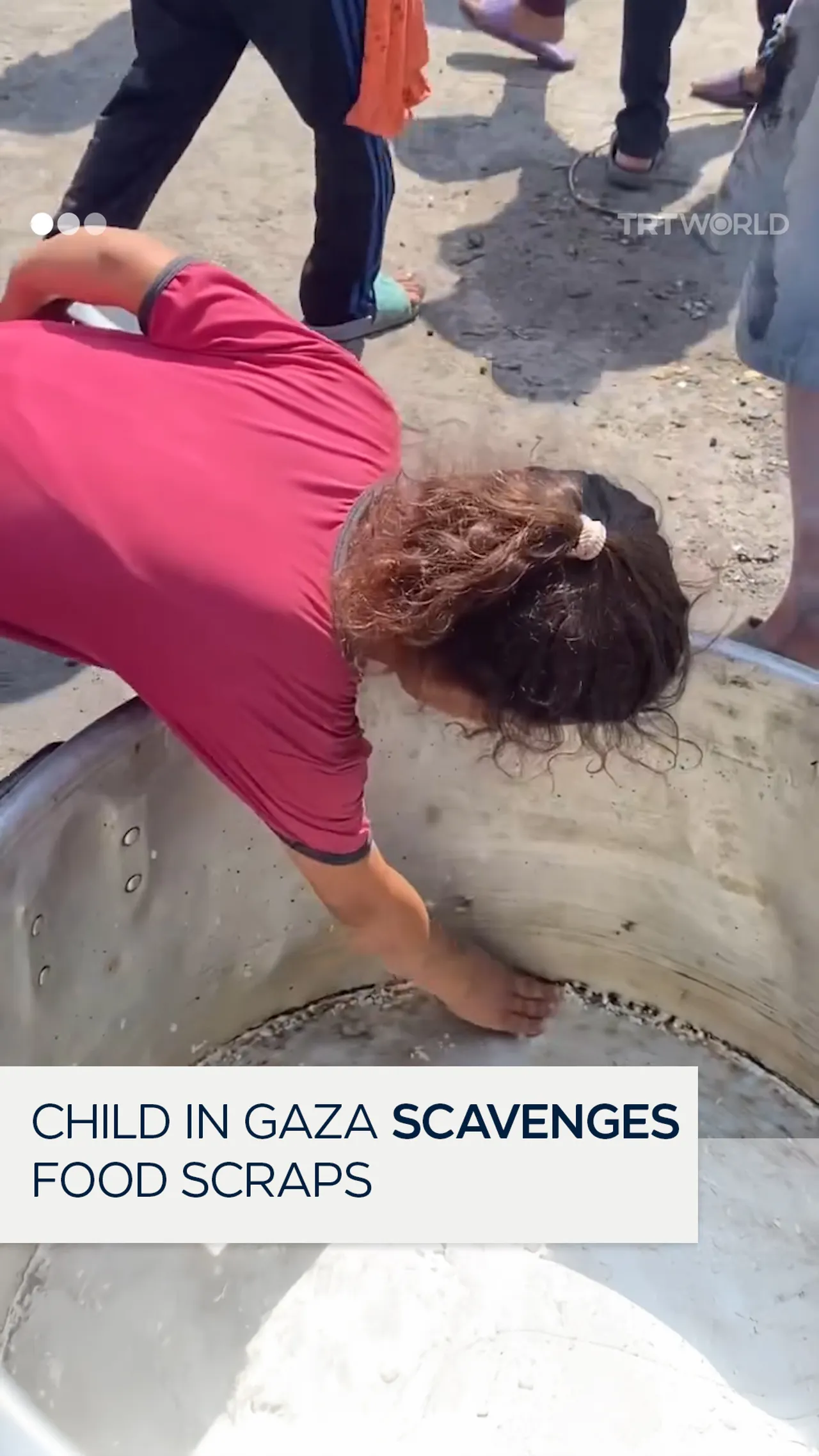 Starving child in Gaza scavenges food scraps out of a cooking pot
