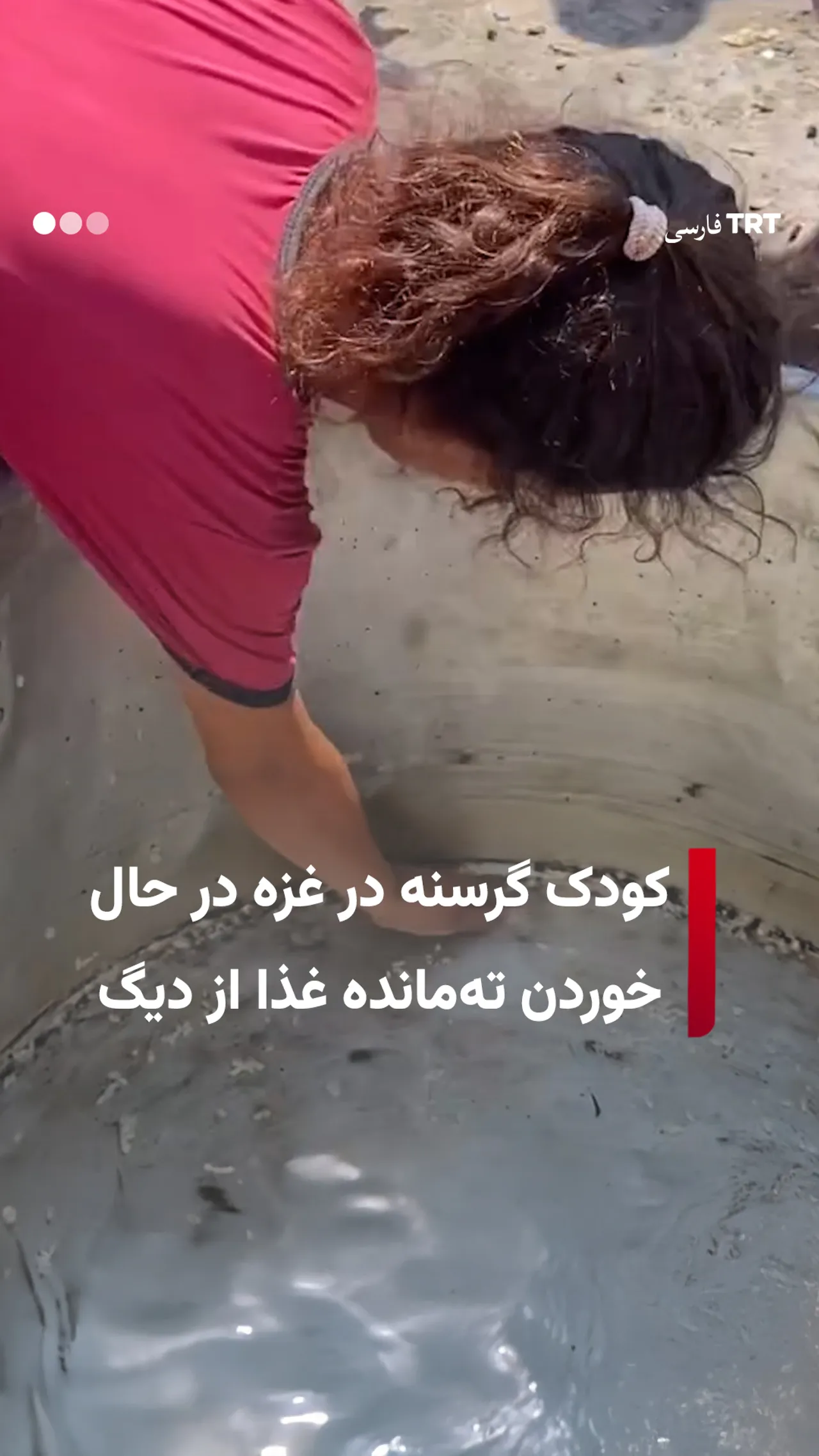 کودک گرسنه در غزه در حال خوردن تهمانده غذا از دیگ