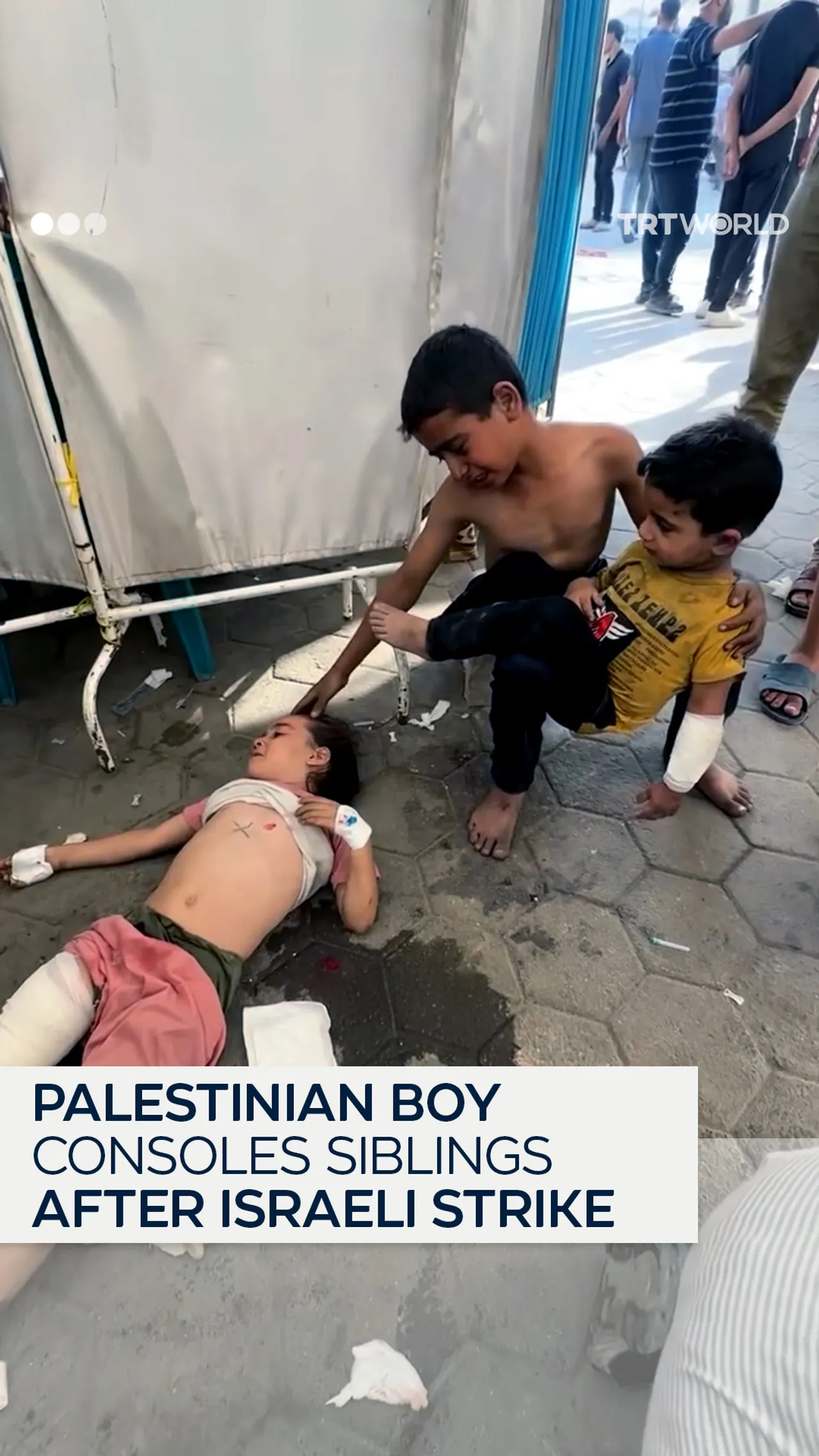 Palestinian boy consoles siblings injured by Israeli strike