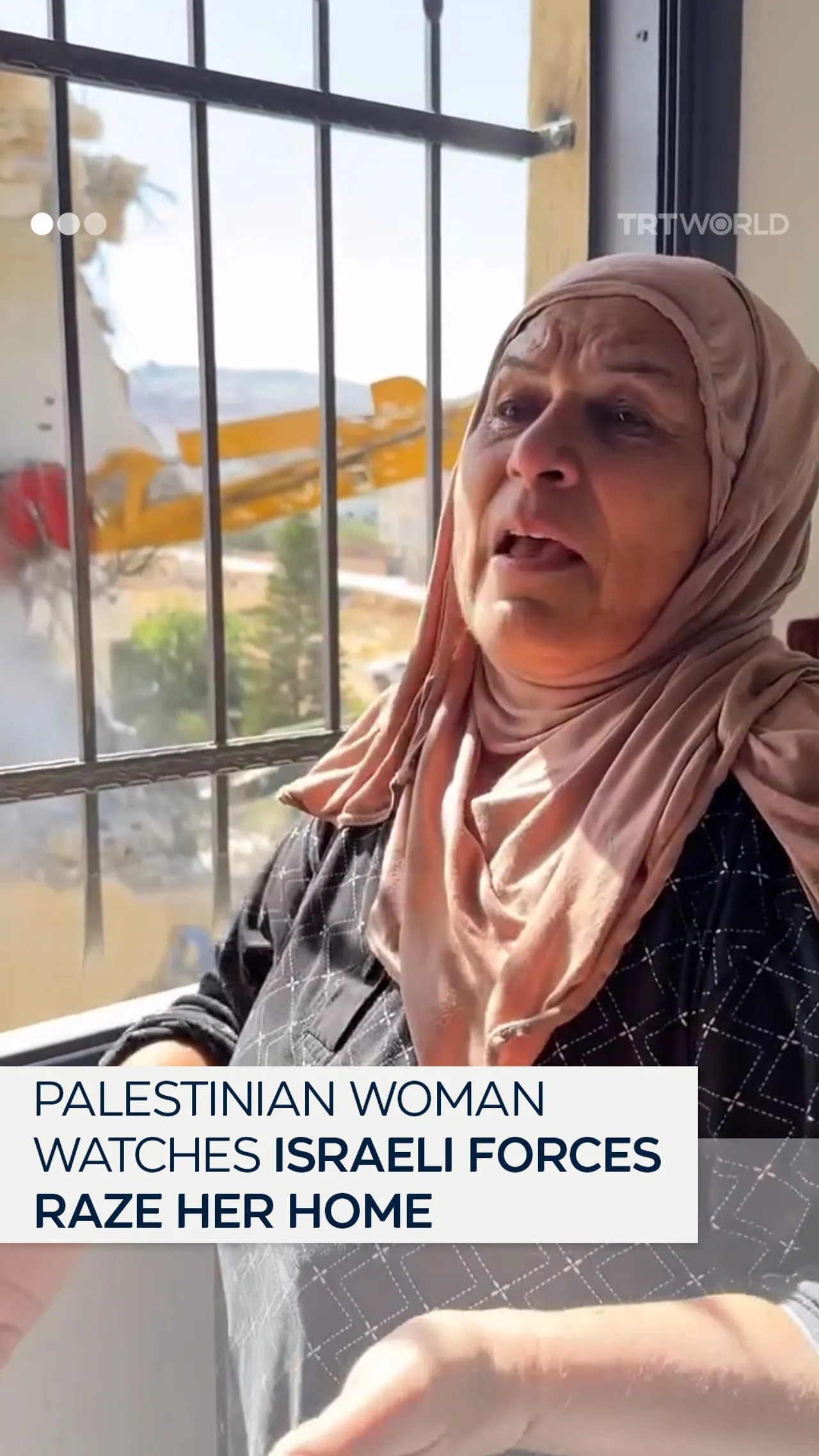 Palestinian woman watches as Israeli forces destroy her home