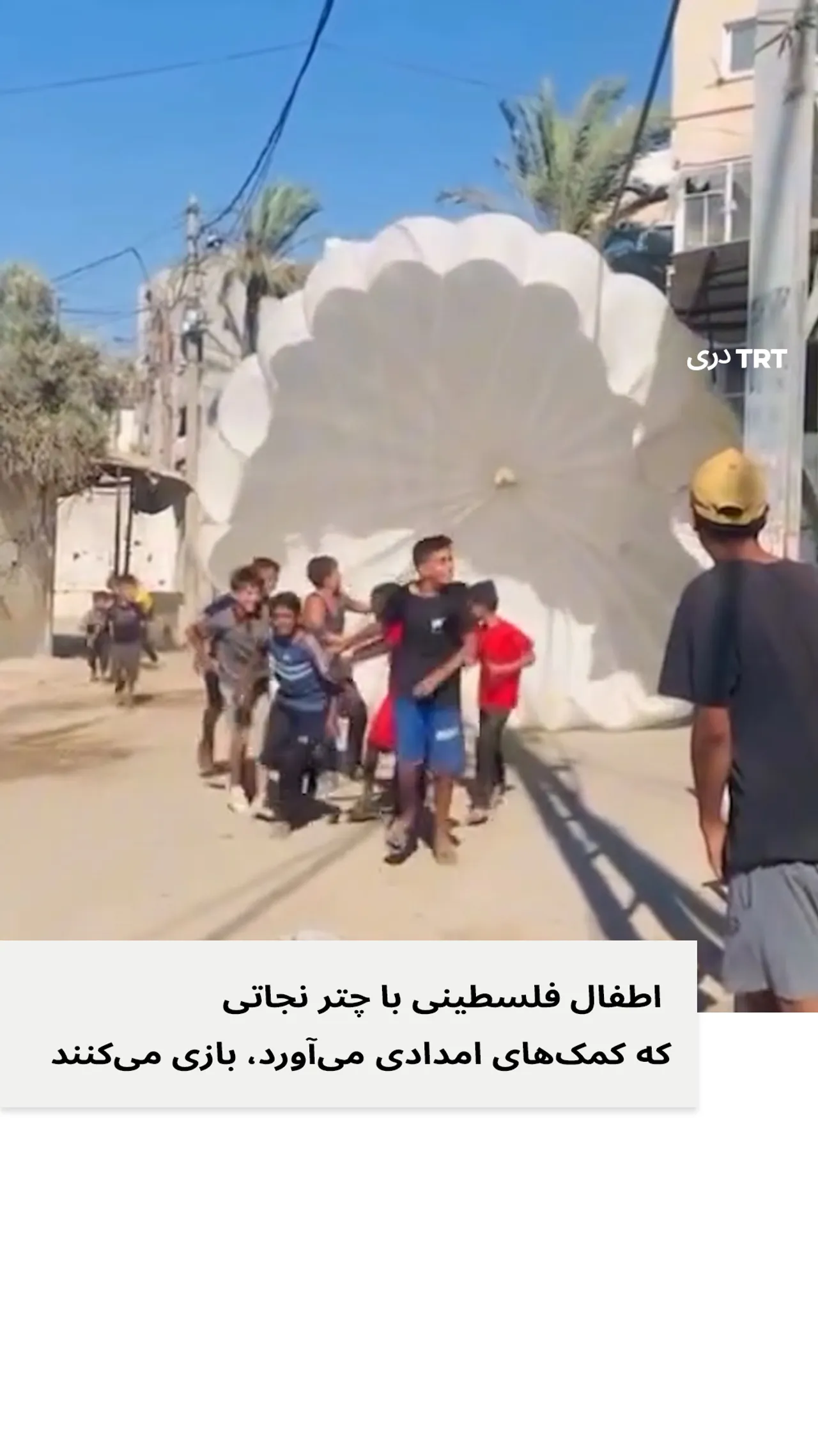 اطفال فلسطینی با چتر نجاتی که کمک های امدادی می آورد، بازی می کنند