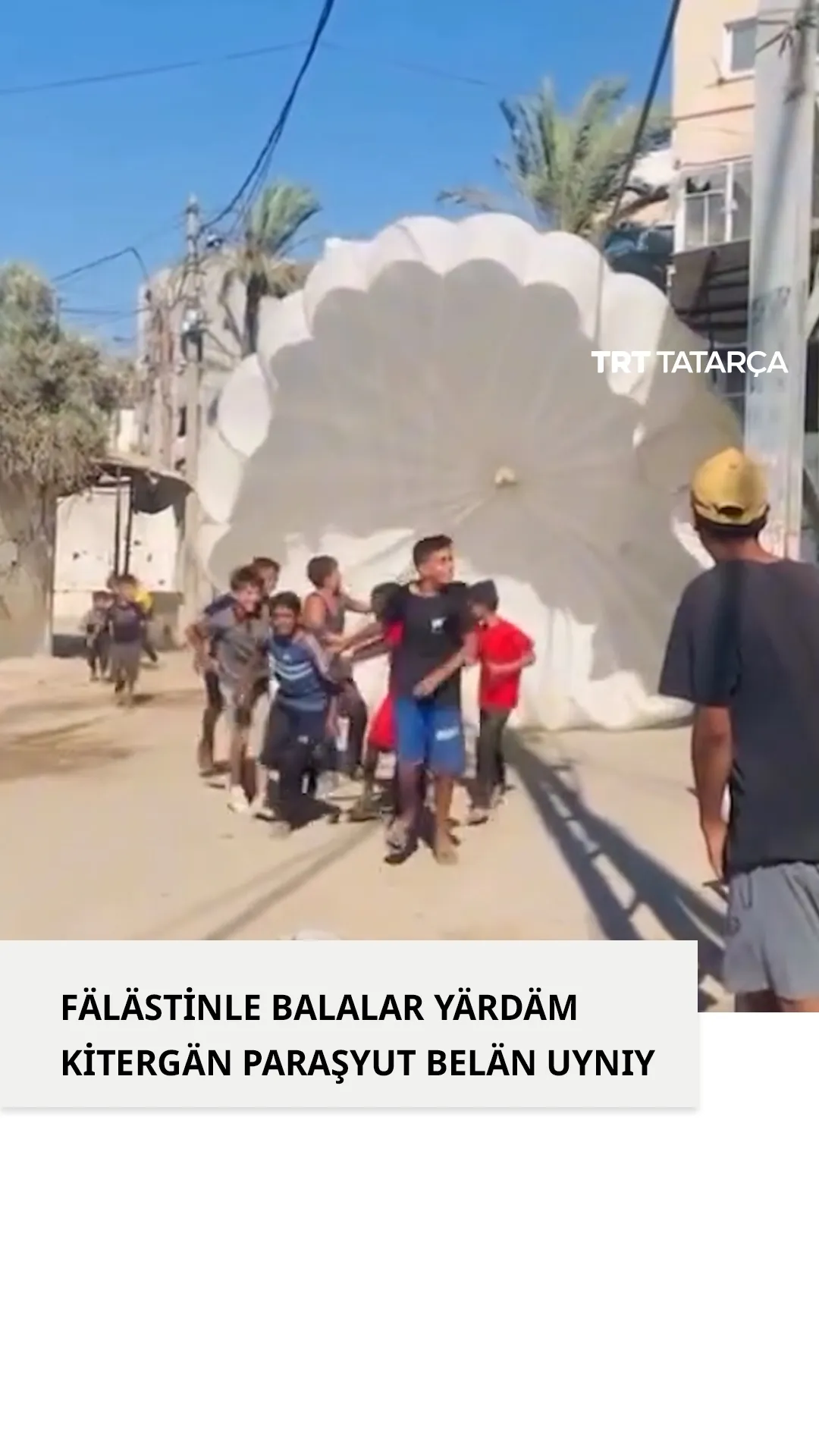 Fälästinle balalar yärdäm töşergän paraşyut belän uynıy