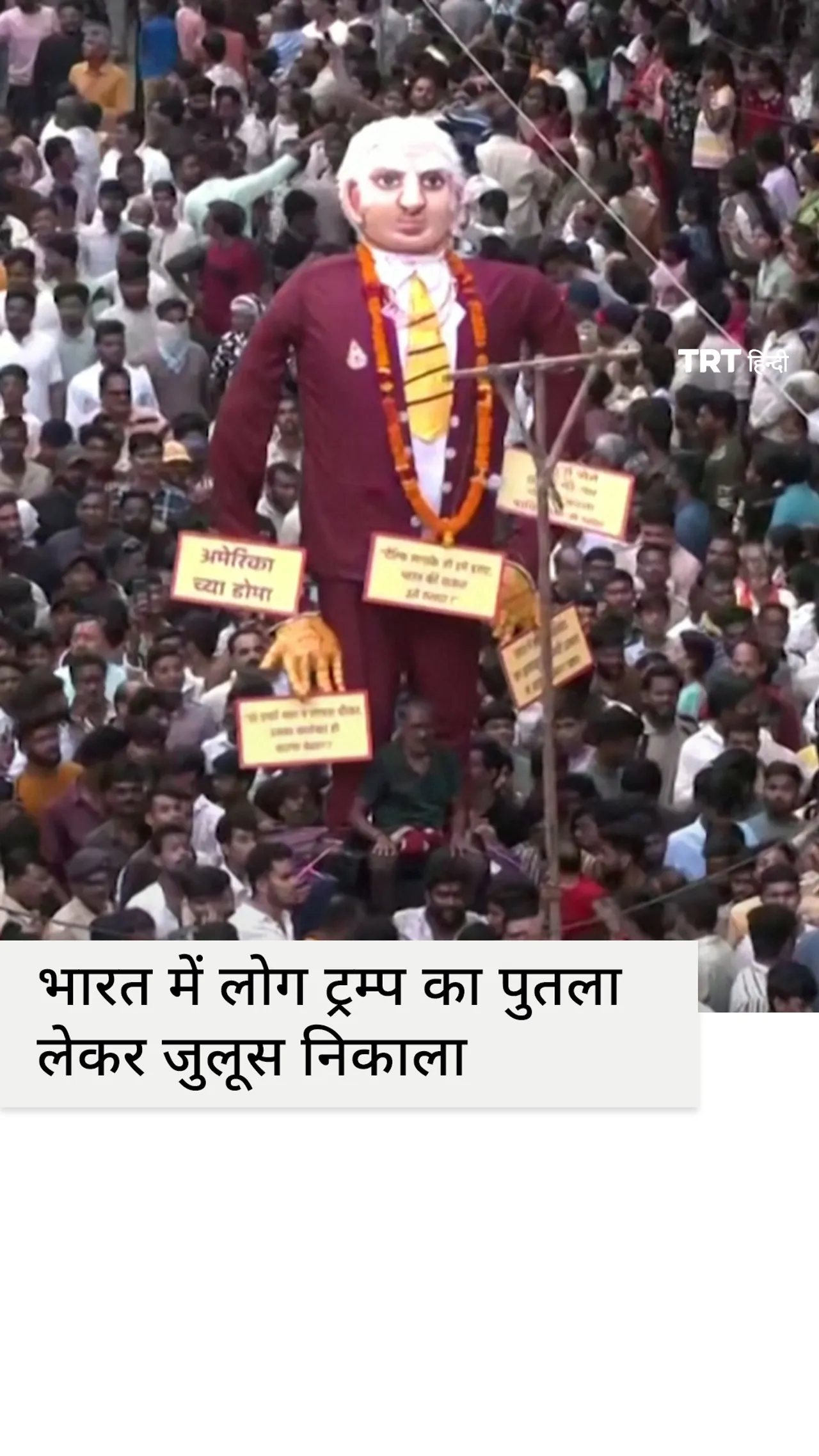 भारत में एक उत्सव जुलूस के दौरान लोग डोनाल्ड ट्रम्प का विशाल पुतला लेकर चलते हैं