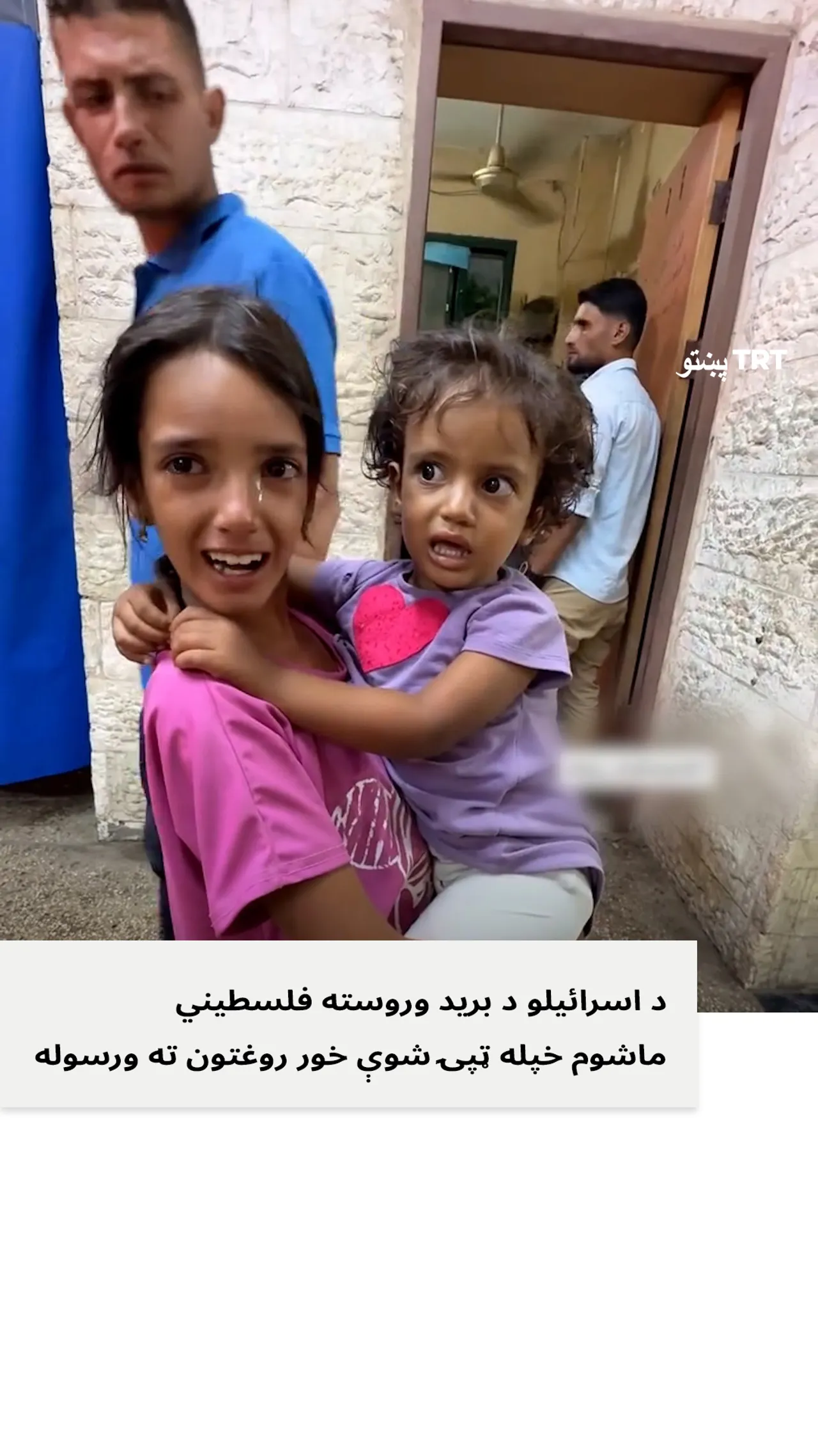 ډاریدلې فلسطیني ماشومې خپله خور چې ویل يي د اسرائیلو په برید کې ټپي شوې روغتون ته راوړله.