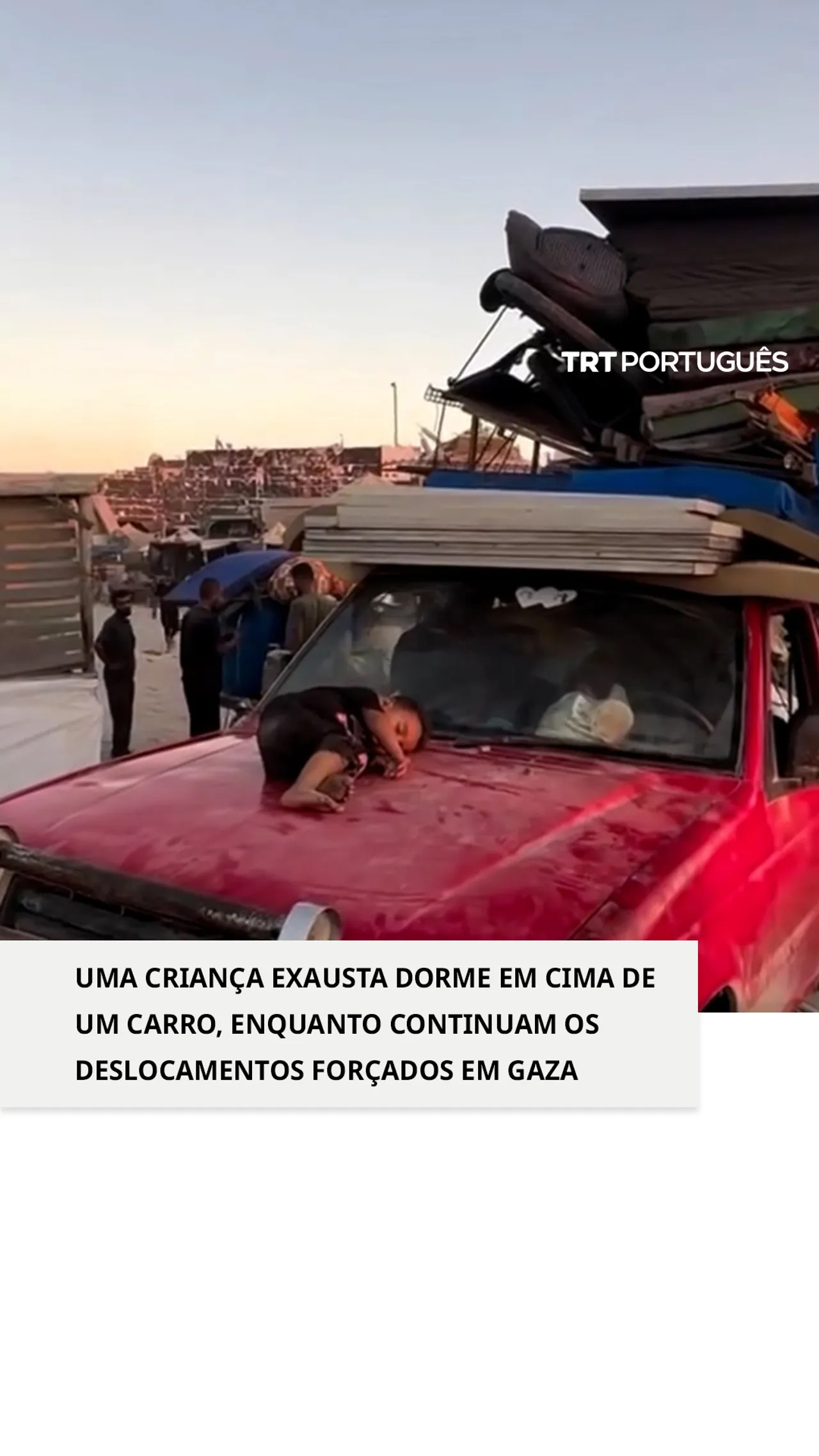 Uma criança exausta dorme em cima de um carro, enquanto continuam os deslocamentos forçados em Gaza