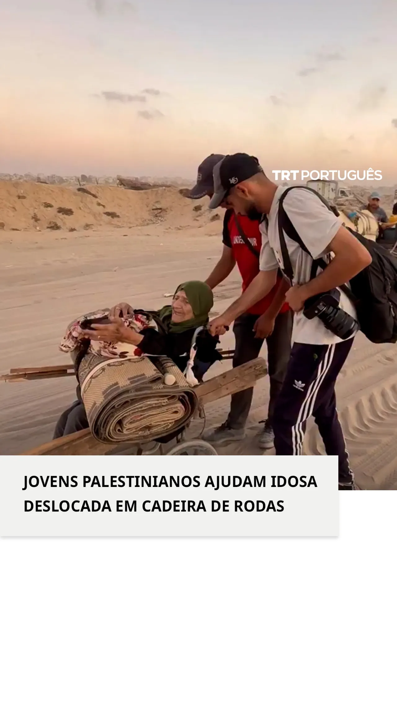 Jovens palestinianos ajudam idosa deslocada em cadeira de rodas