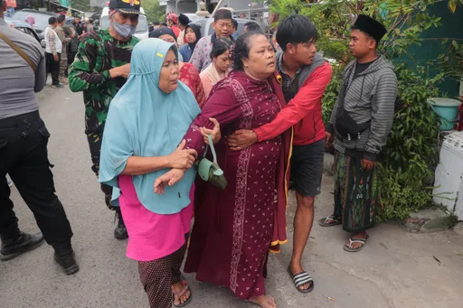 Keluarga berduka dan menunggu saat tim penyelamat menggali reruntuhan pondok pesantren di Sidoarjo