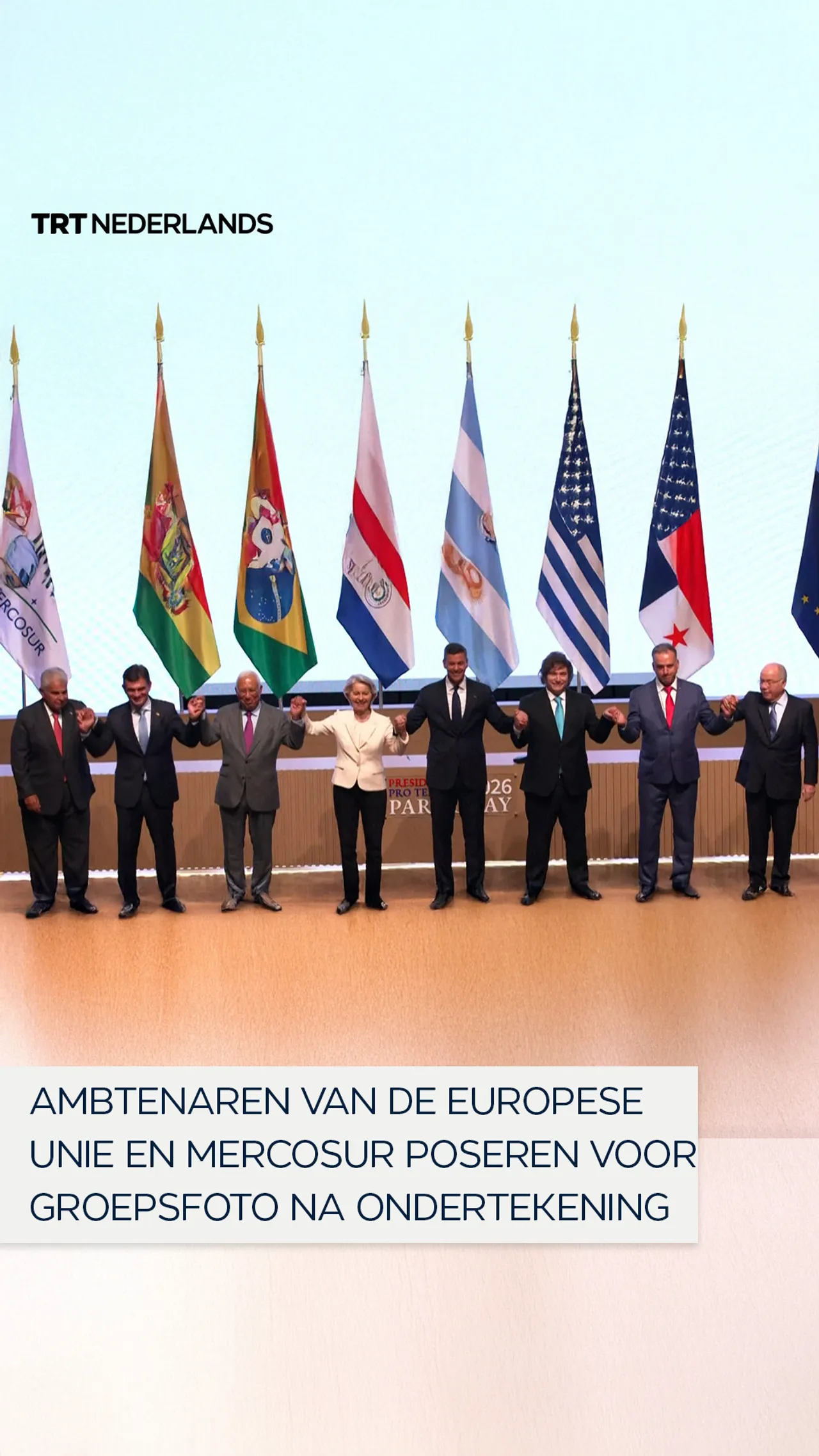 Ambtenaren van de Europese Unie en Mercosur poseren voor groepsfoto na ondertekening