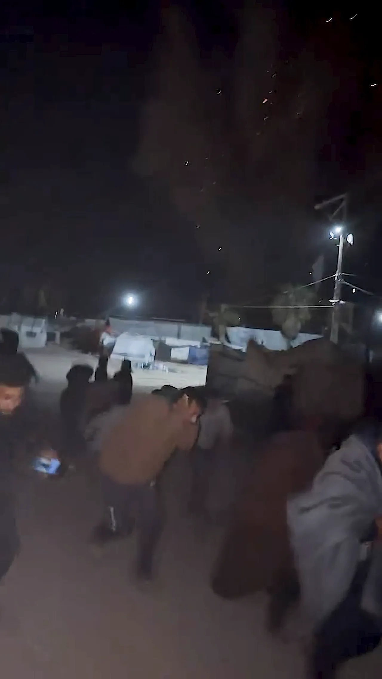 Warga Palestina bergegas mengamankan diri saat Israel menembaki tenda-tenda di Kota Gaza