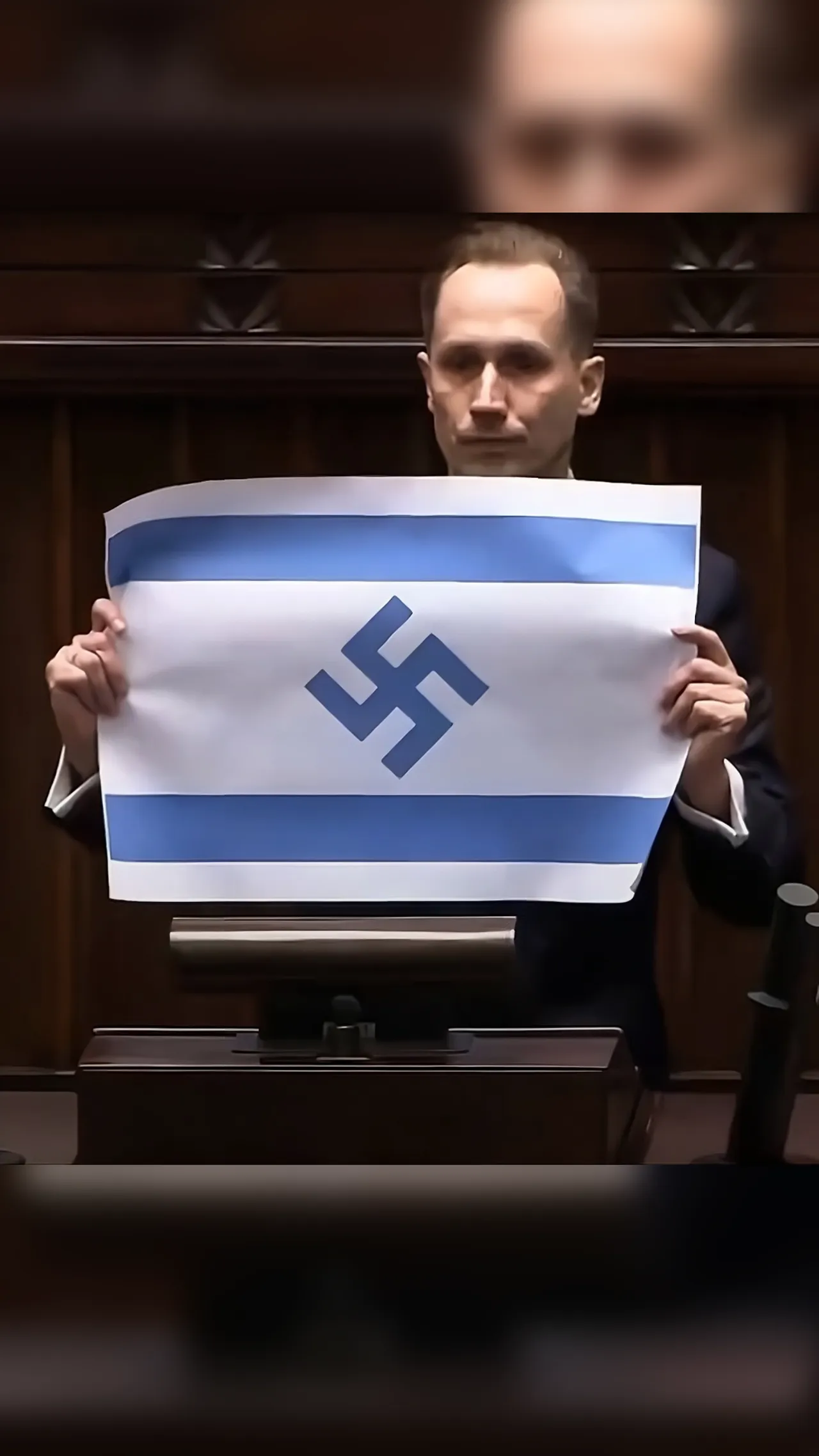 Anggota Parlemen Polandia menunjukkan bendera Israel bersimbol swastika Nazi