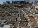 Relatives search for signs of loved ones in a Syrian cemetery left in ruins by the Assad regime