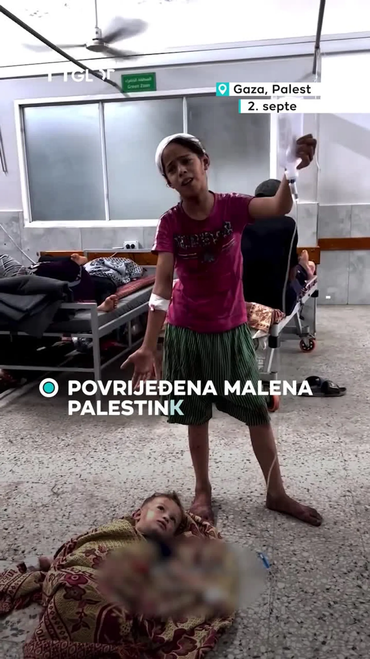 Povrijeđena malena Palestinka drži bocu s infuzijom za malog dječaka
