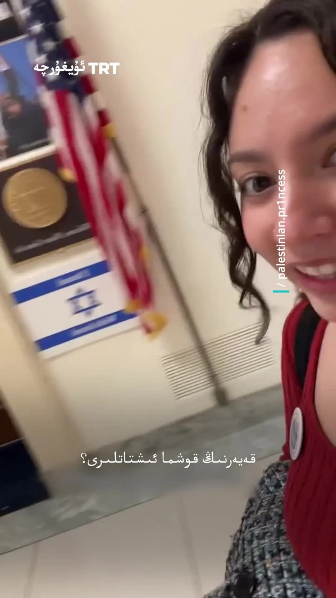 بىر پائالىيەتچى ئىسرائىلىيە بايراقلىرى بىلەن تولغان ئامېرىكا كونگرېس كارىدورلىرىنى سىنغا ئالدى